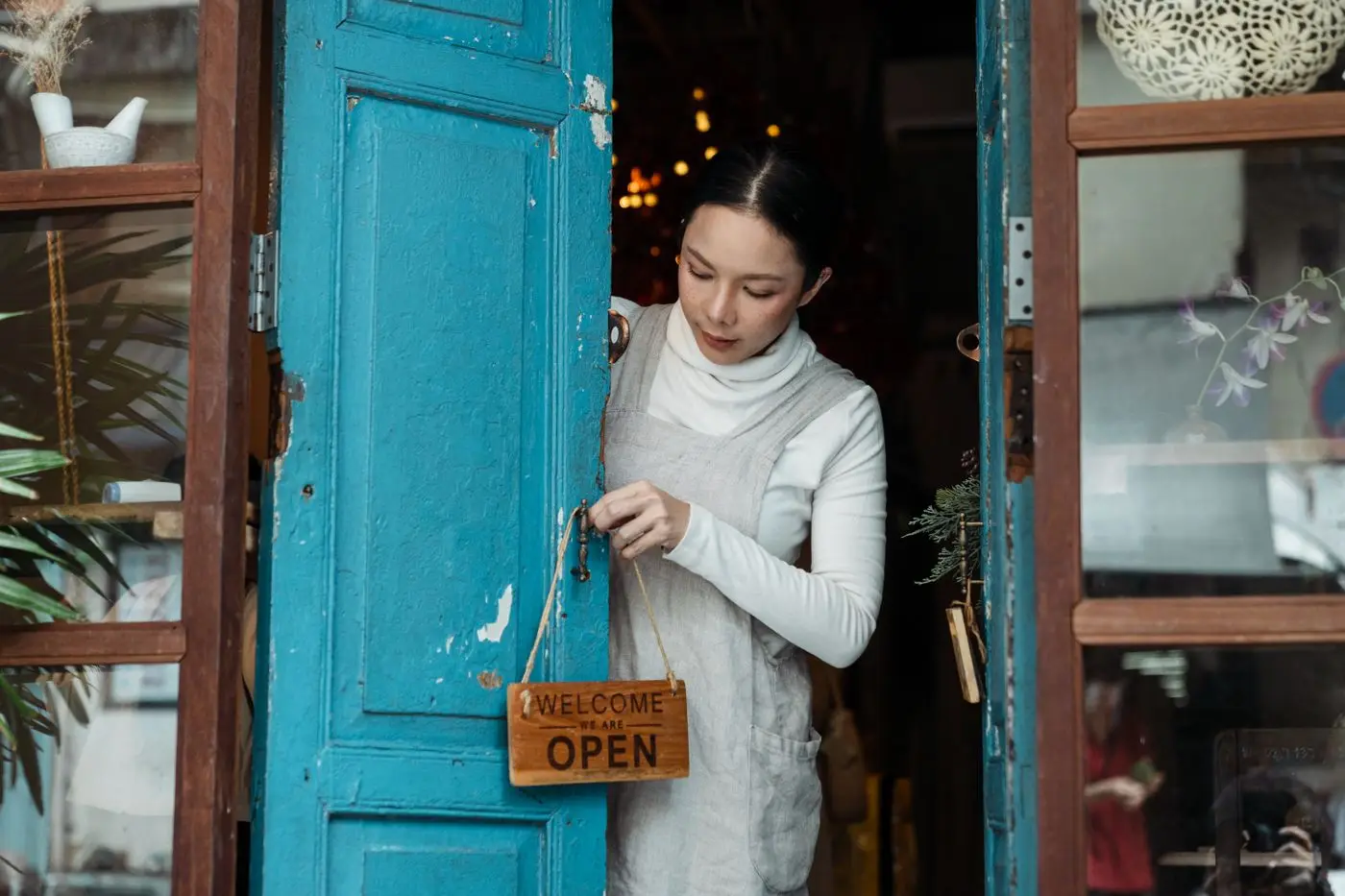 Shop owner opening up with an open sign